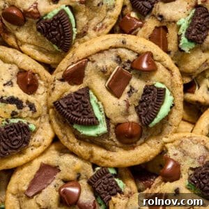 Close-up of baked mint chocolate chip cookies, adorned with mint Oreos and Andes mint pieces on top.