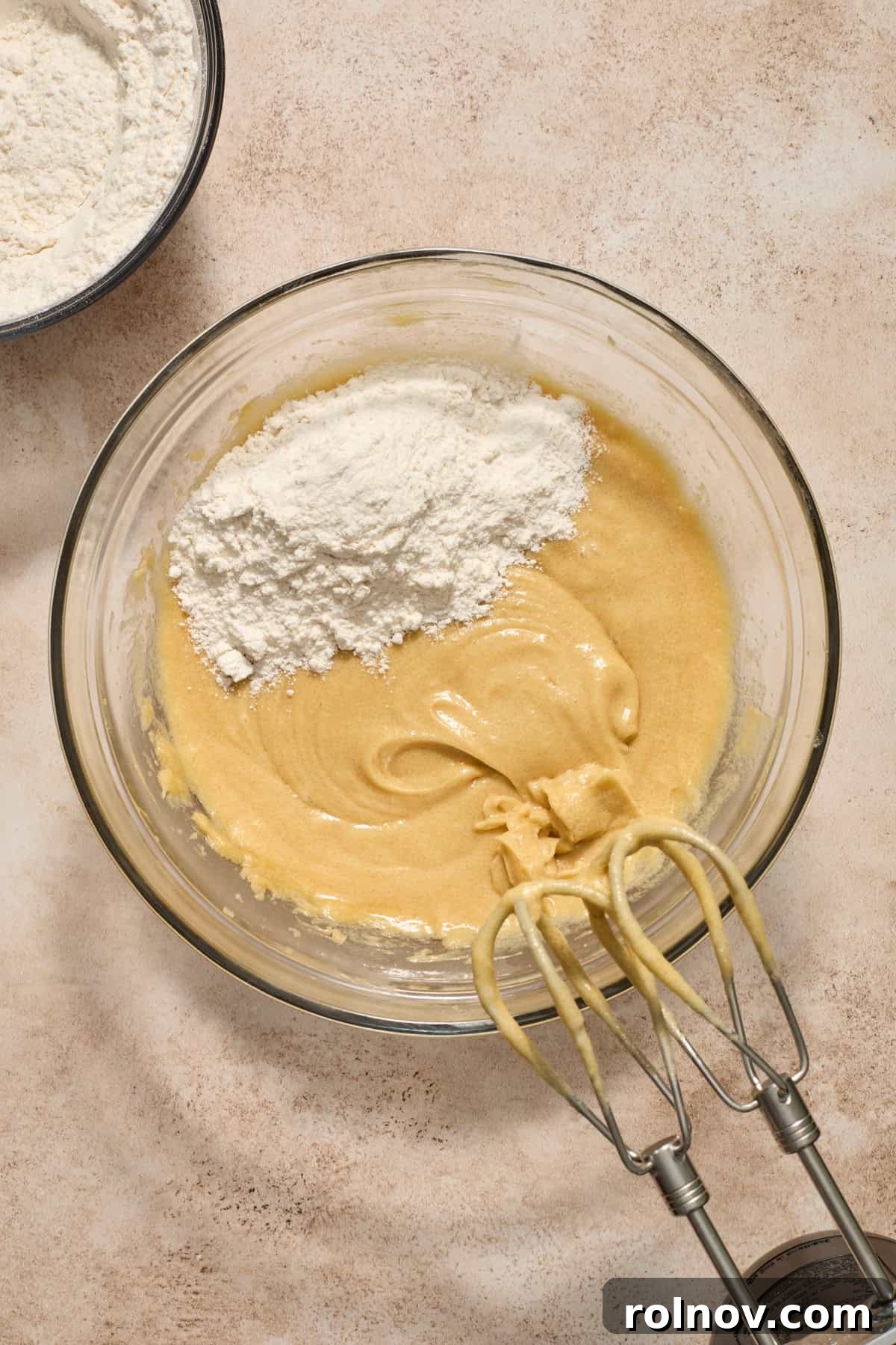 Cookie dough showing the incorporation of some dry ingredients into the wet mixture, creating a thick batter.