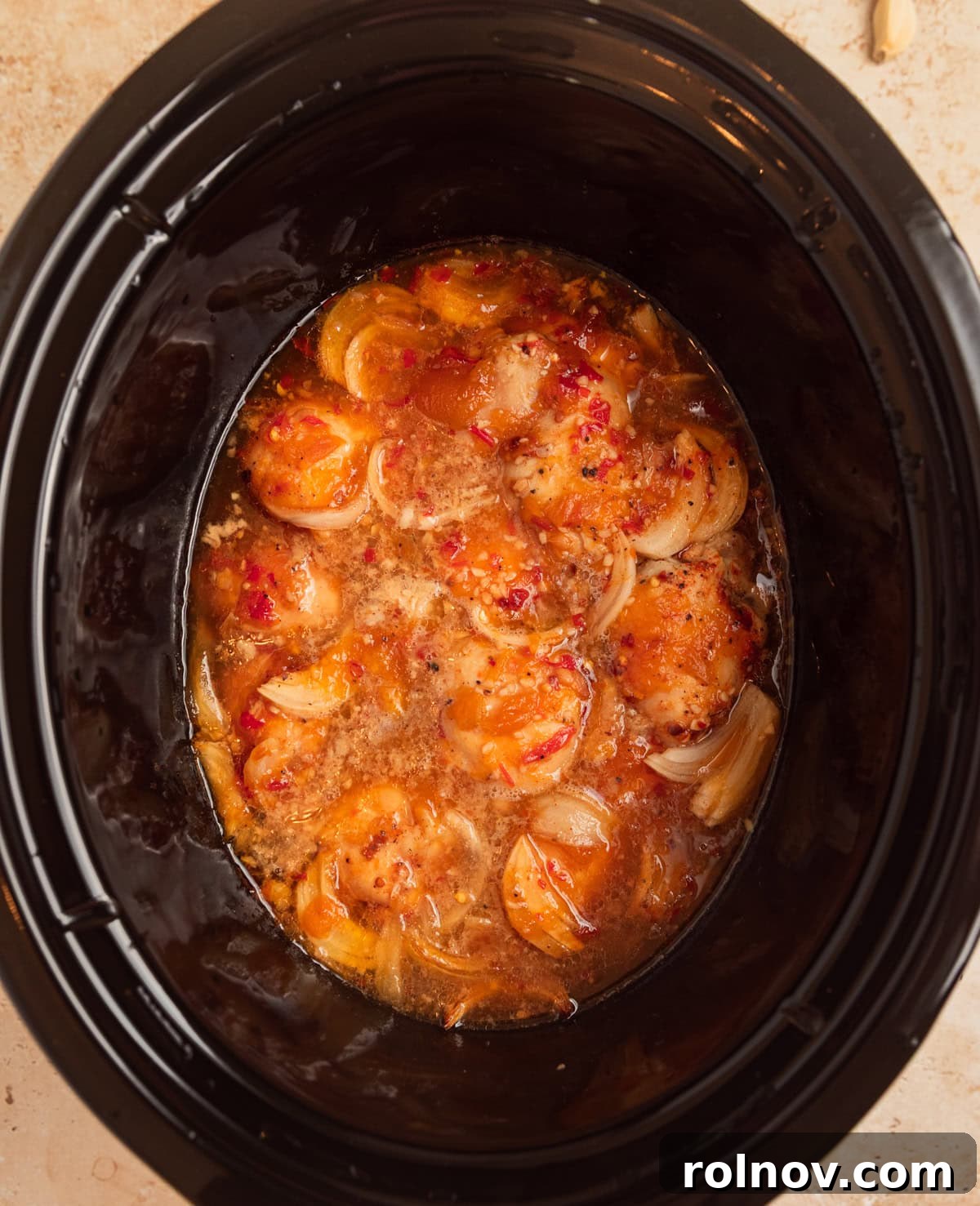 Sweet and Savory Apricot Slow-Cooked Chicken 7 Cooked chicken thighs in sauce in slow cooker pot.