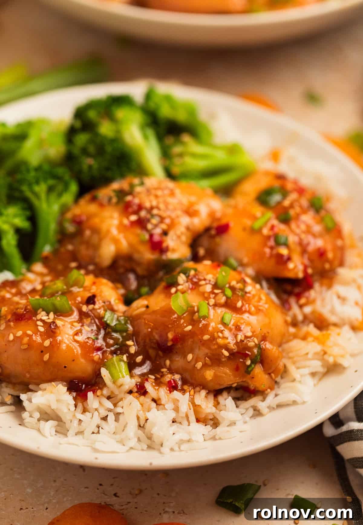 Sweet and Savory Apricot Slow-Cooked Chicken 10 Plate with crockpot apricot chicken over rice and served with broccoli.