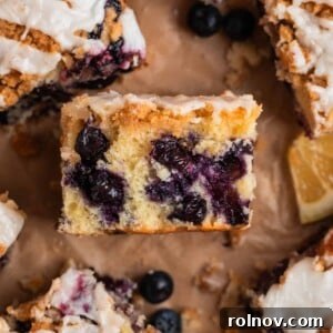 Slice of blueberry lemon coffee cake with streusel topping laid on its side to show texture.