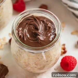 Jar of nutella overnight oats with raspberries beside it.