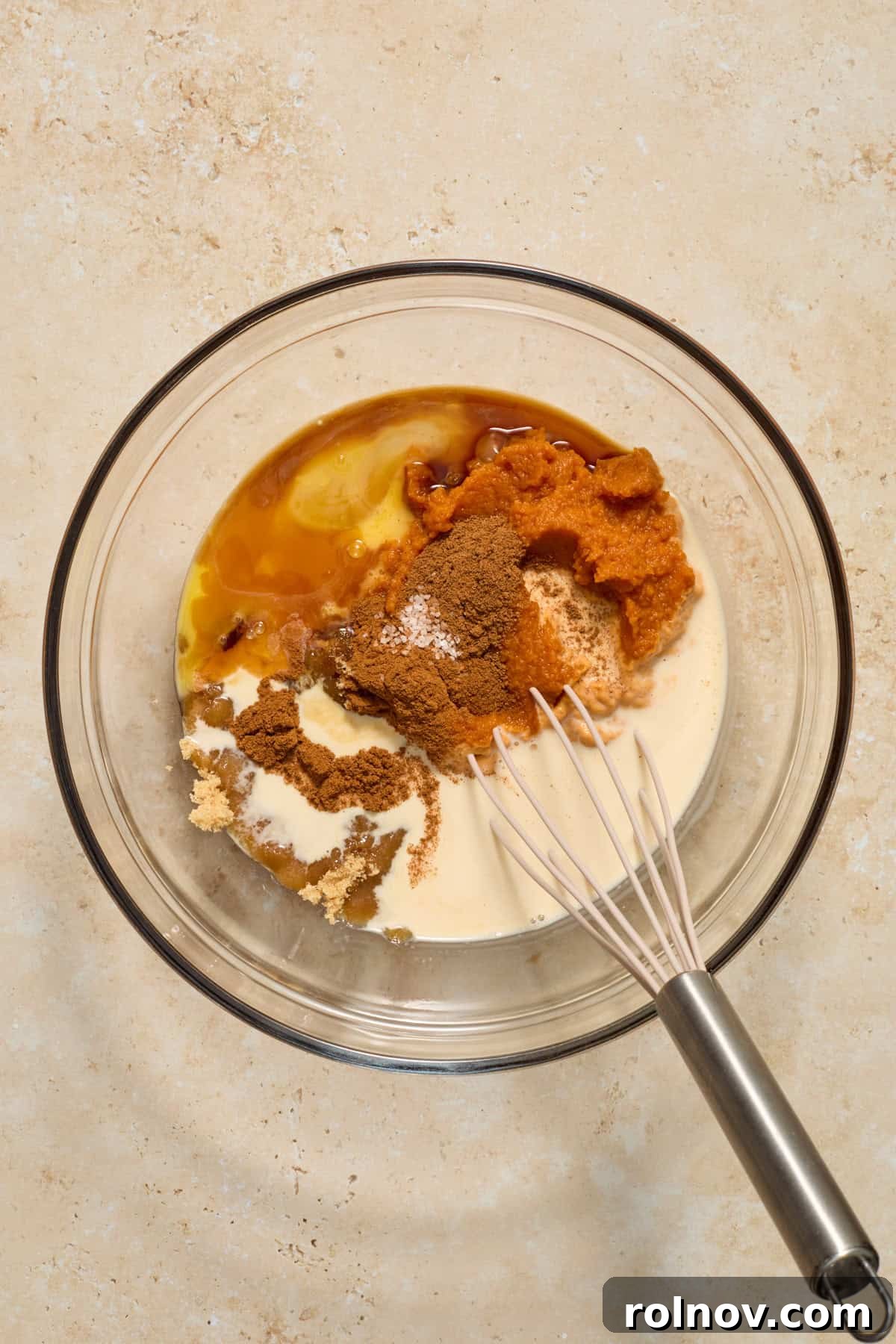 Bite-Sized Pumpkin Delights 5 Pumpkin purée, evaporated milk, egg, butter, and various spices are gathered in a medium mixing bowl, ready to be combined.