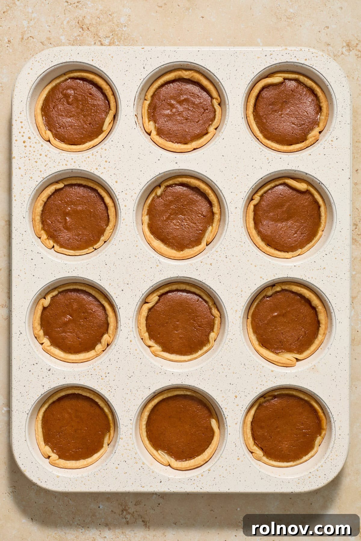 Bite-Sized Pumpkin Delights 10 A muffin tin filled with perfectly baked mini pumpkin pies, with golden crusts and set filling, just out of the oven.