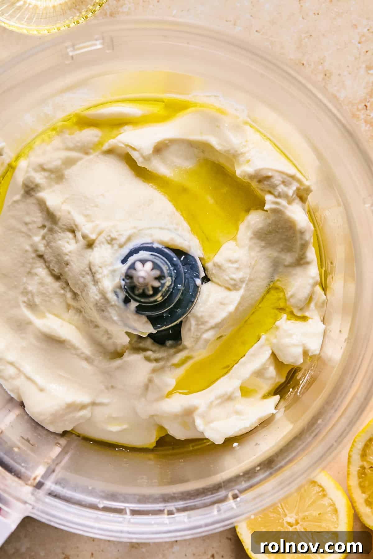 Ricotta cheese, fresh lemon juice, sea salt, and olive oil being combined in a food processor.