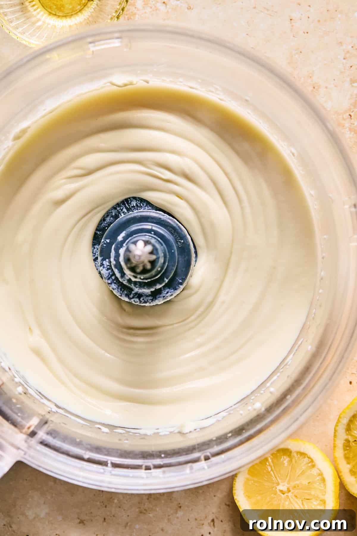 Close-up of perfectly smooth and creamy whipped ricotta in a food processor.