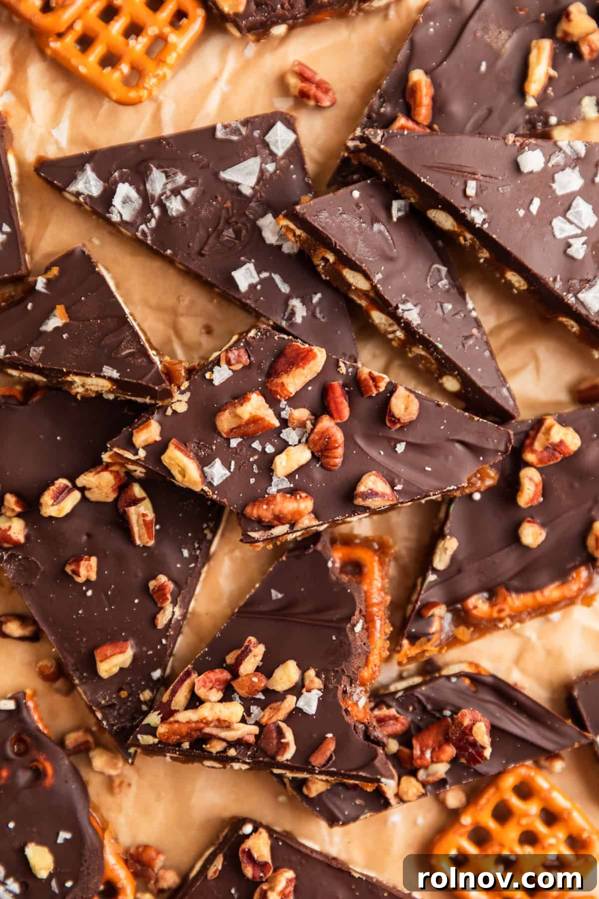 Salty Sweet Pretzel Toffee Crunch 2 Crispy pretzel toffee pieces generously topped with chopped pecans and a sprinkle of flaky sea salt, showcasing its irresistible texture and flavor.