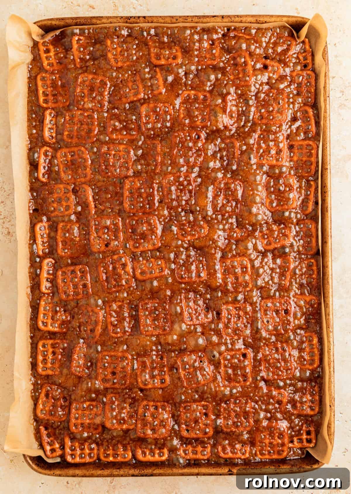 Salty Sweet Pretzel Toffee Crunch 9 The caramel-covered pretzels baking in the oven, with the caramel visibly bubbling vigorously, indicating it's reaching the desired temperature.