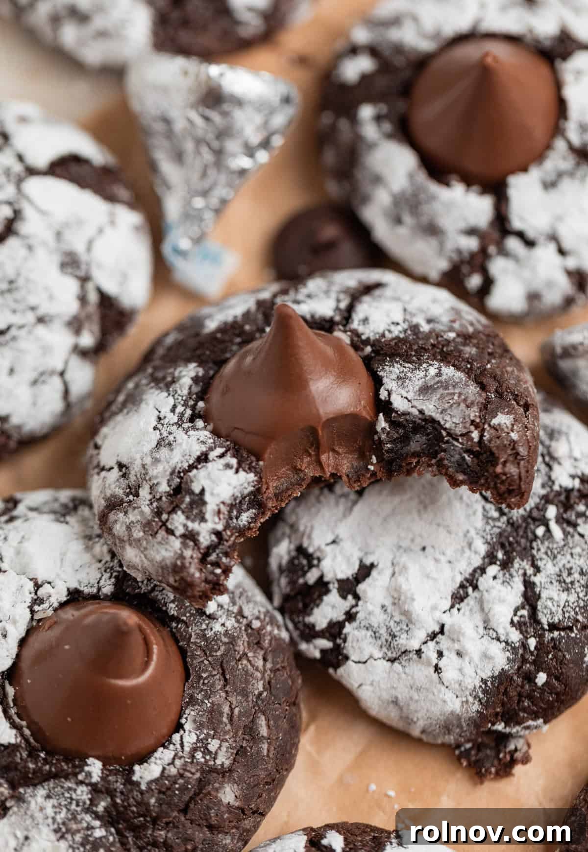 Velvet Chocolate Crinkle Blossoms 10 Chocolate blossom cookies with bite taken out of one cookie.