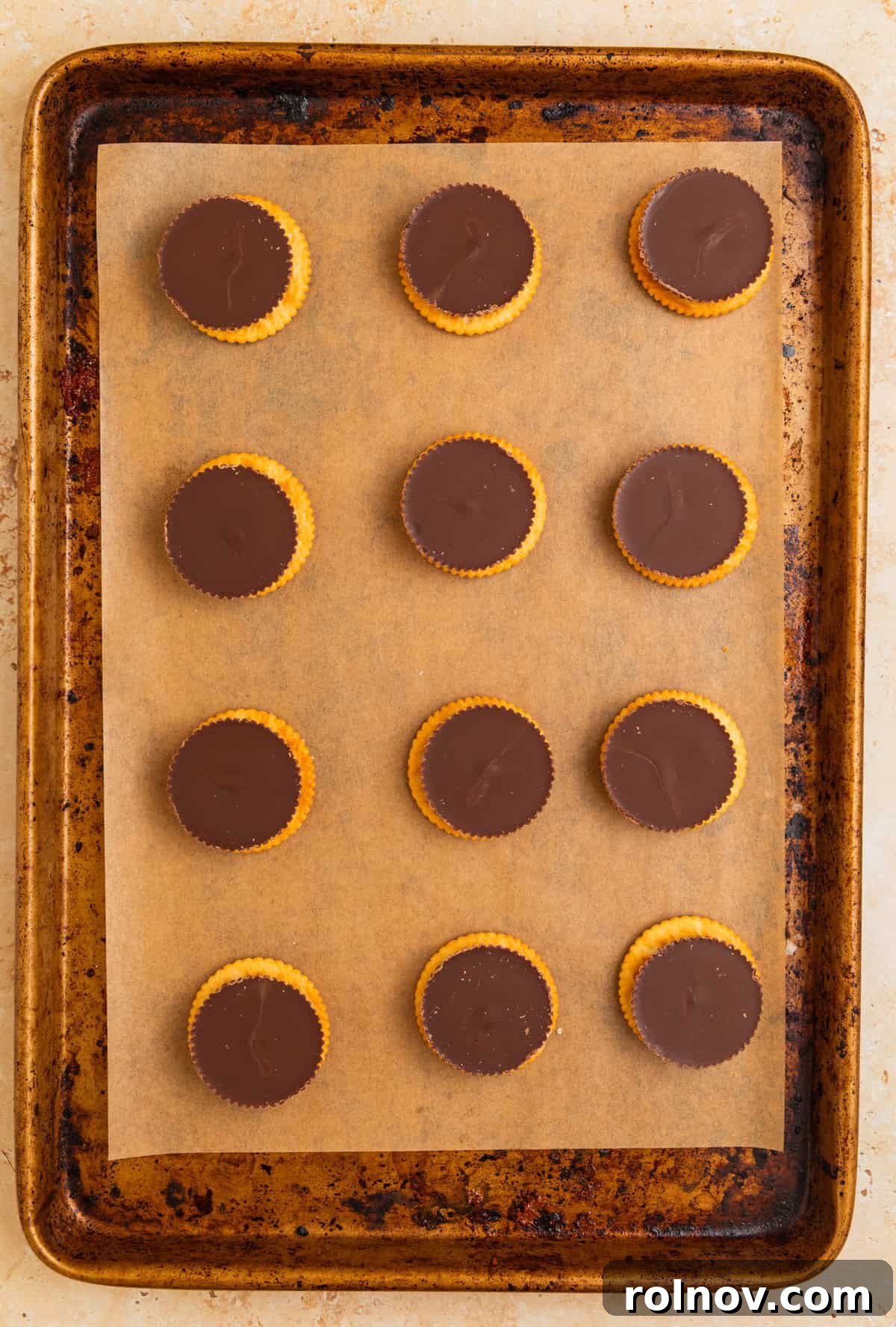 Reese cup thin on ritz crackers on parchment lined baking sheet.