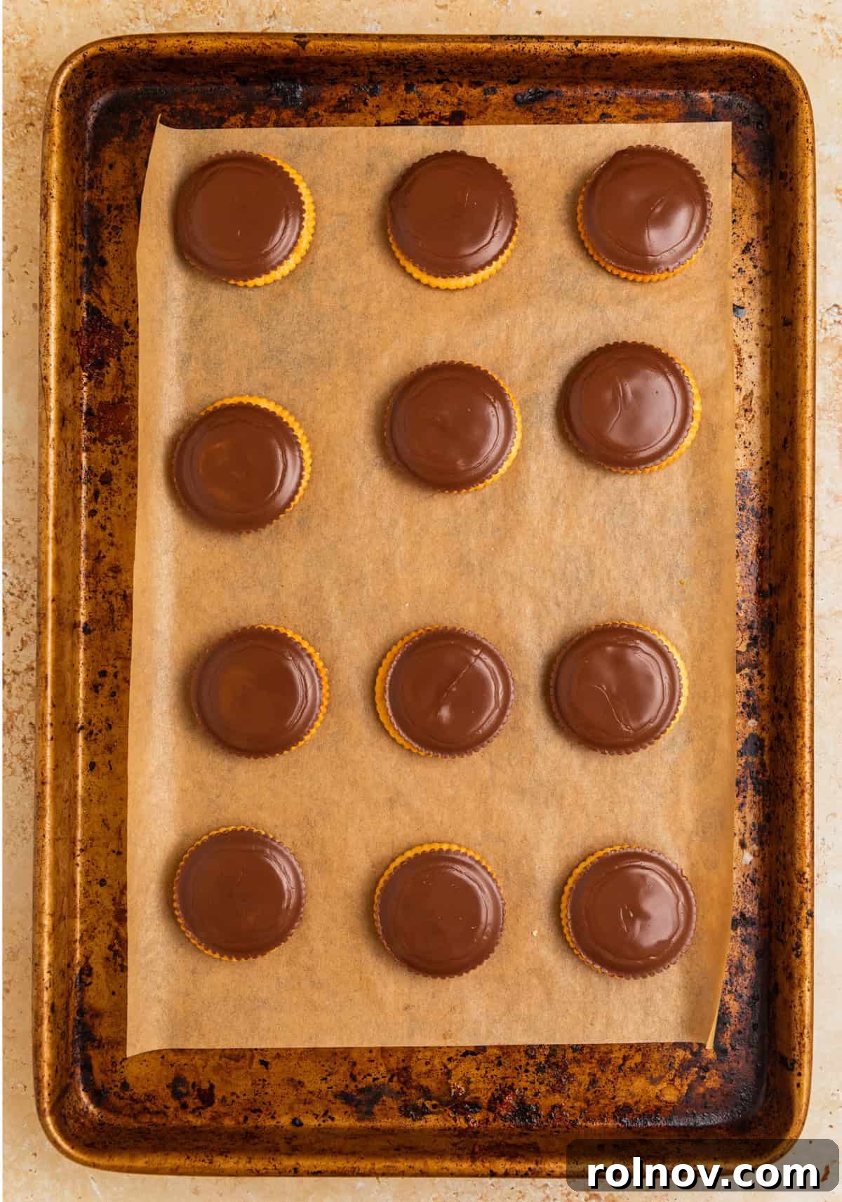 Melted peanut butter cups on crackers on pan.