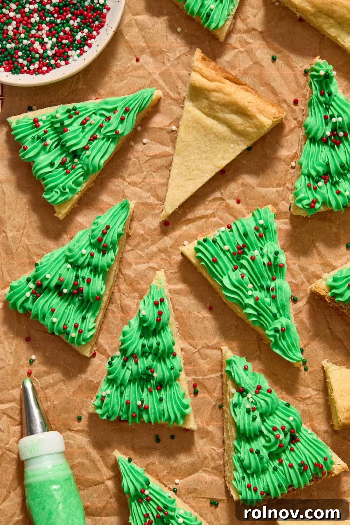 Frosted Christmas sugar cookie bars on parchment paper, ready to be served.