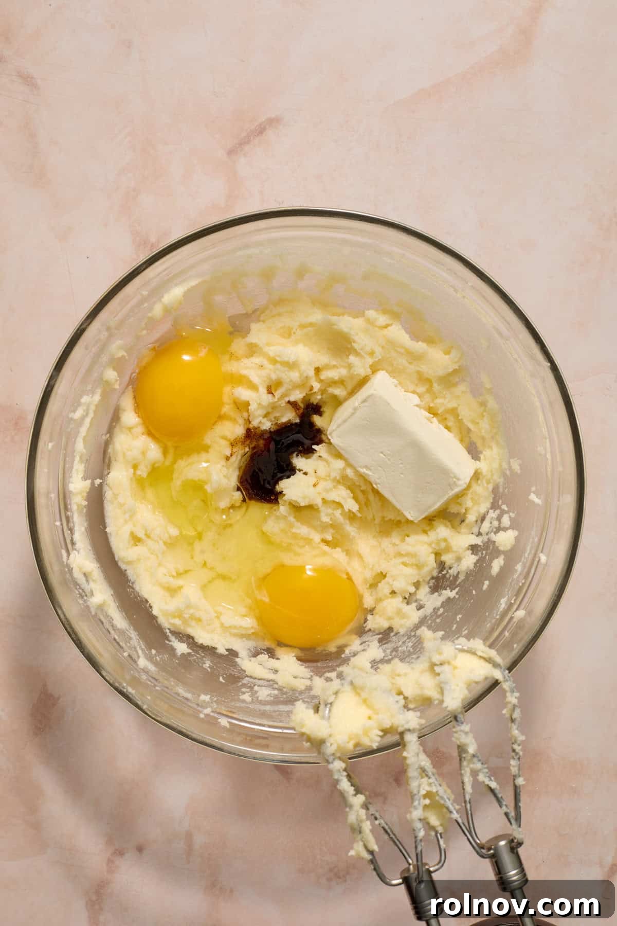 Eggs, vanilla, almond extract, and cream cheese added to creamed butter and sugar mixture.
