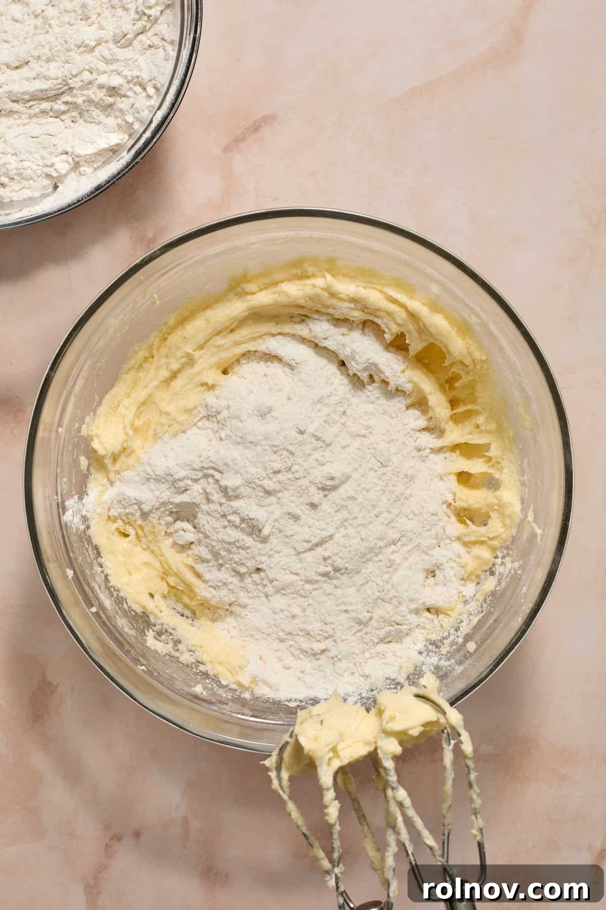 Dry ingredients slowly added to wet ingredients in a mixing bowl.