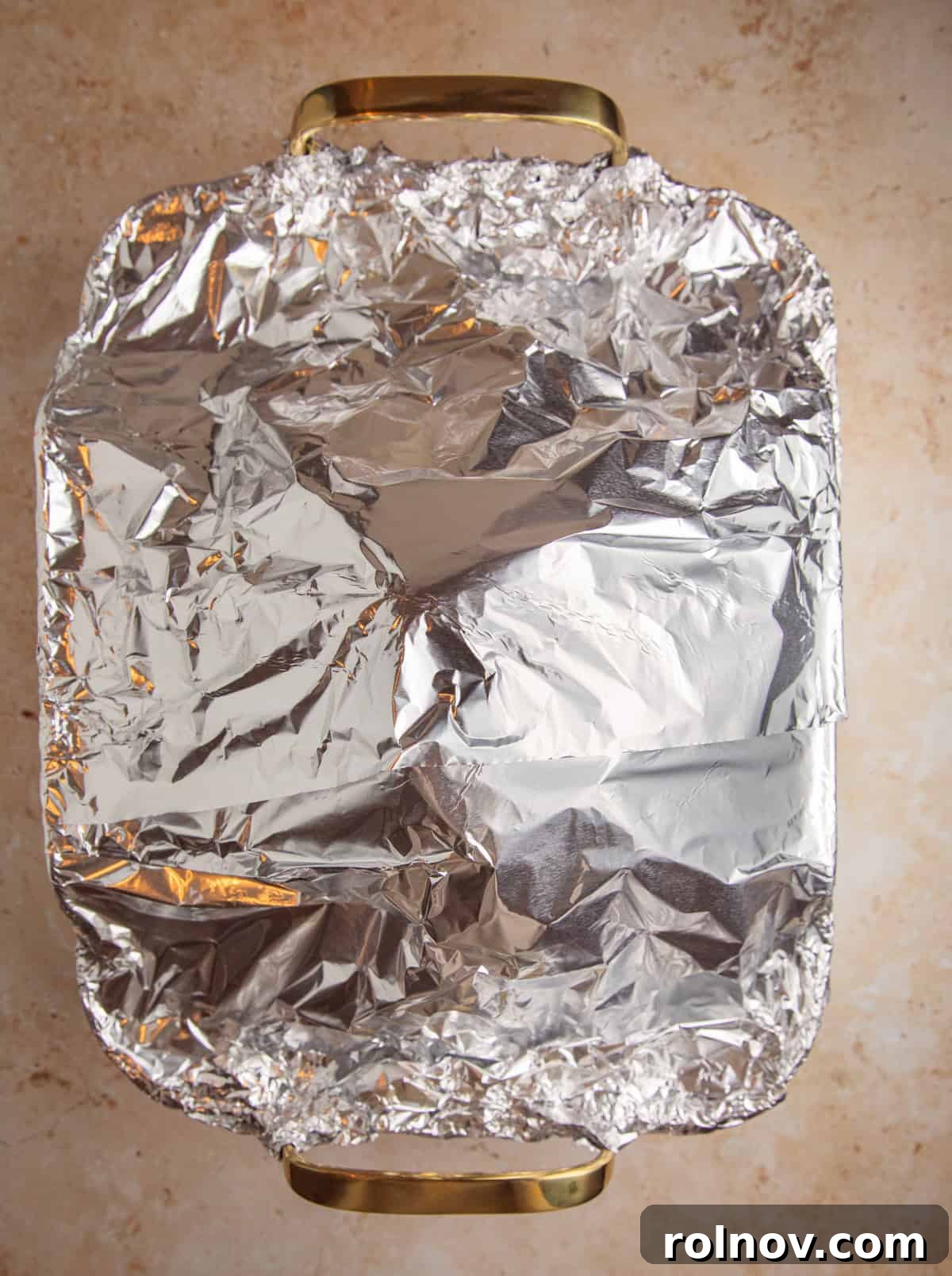 Foil covering ham in roasting pan.