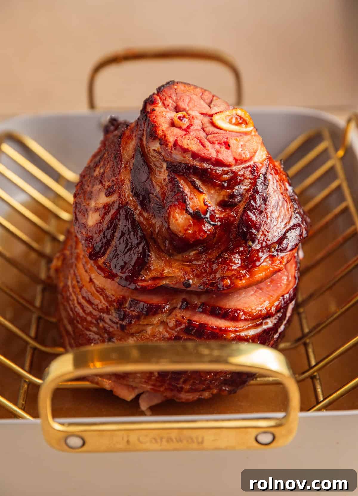 Apricot glazed ham after heating glaze in roasting pan.