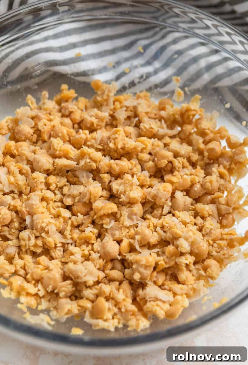 Plant-Based Chickpea Tuna Salad 5 Chickpeas mashed in a glass mixing bowl, ready for other ingredients.