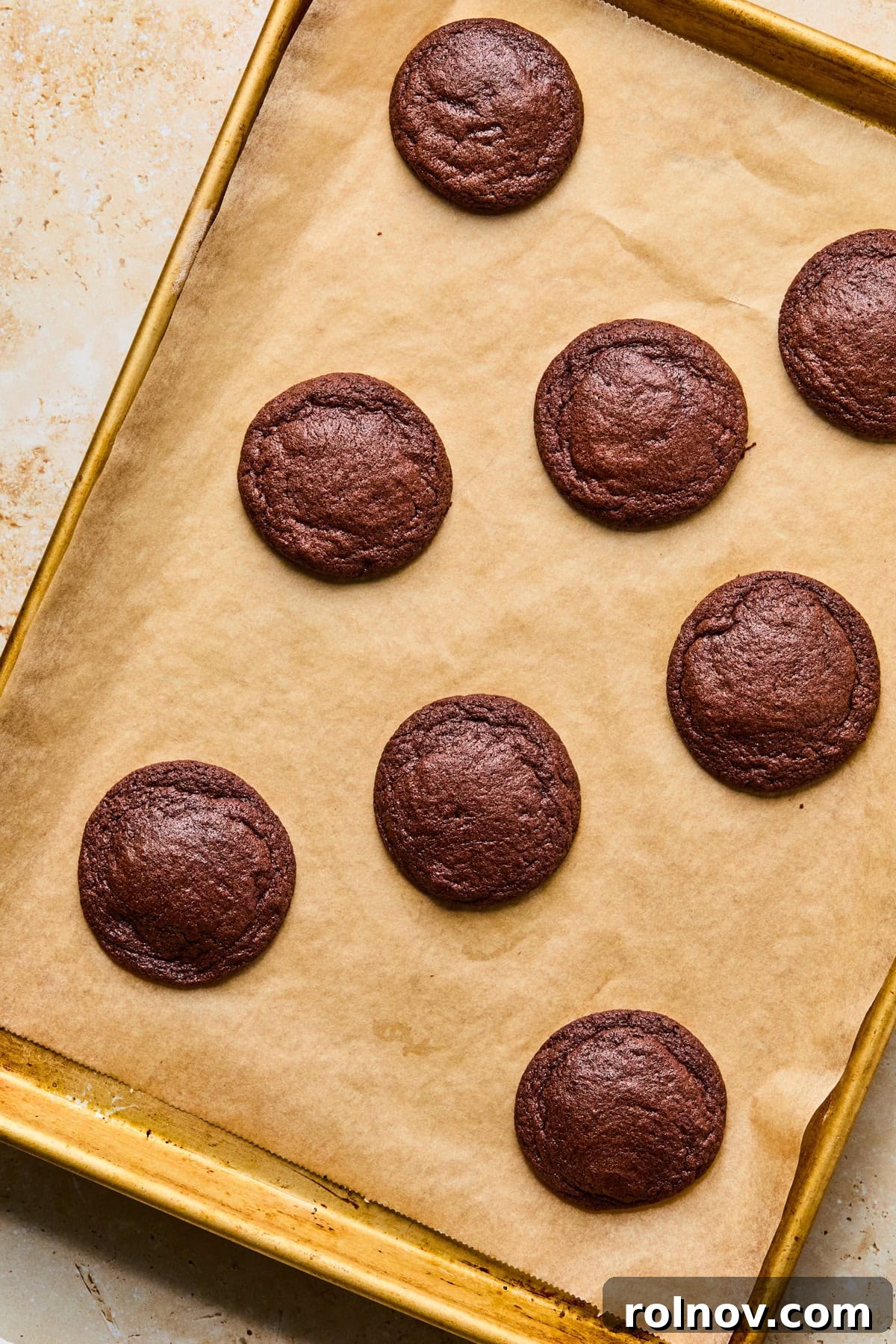 Supernova Brownie Cookies 11 Freshly baked chocolate cookies on a cookie sheet, slightly puffed and with set edges.