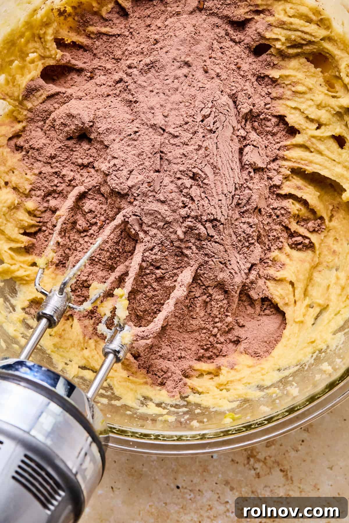Supernova Brownie Cookies 8 Cocoa powder and flour mixture being gradually added to the wet ingredients in a mixing bowl.