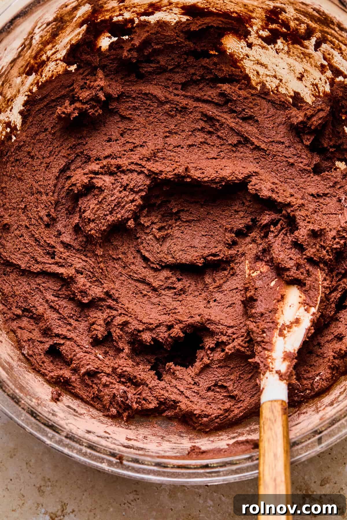 Supernova Brownie Cookies 9 Rich chocolate cosmic brownie cookie dough in a mixing bowl with a spatula, ready for scooping.