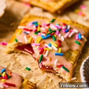 Delectable homemade pop tart made with pie crust, on parchment paper, with a bite taken out.