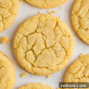 Soft and chewy lemon sugar cookies laid out on a counter with scattered crumbs.