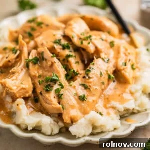 Slow cooker honey mustard chicken served over fluffy mashed potatoes.