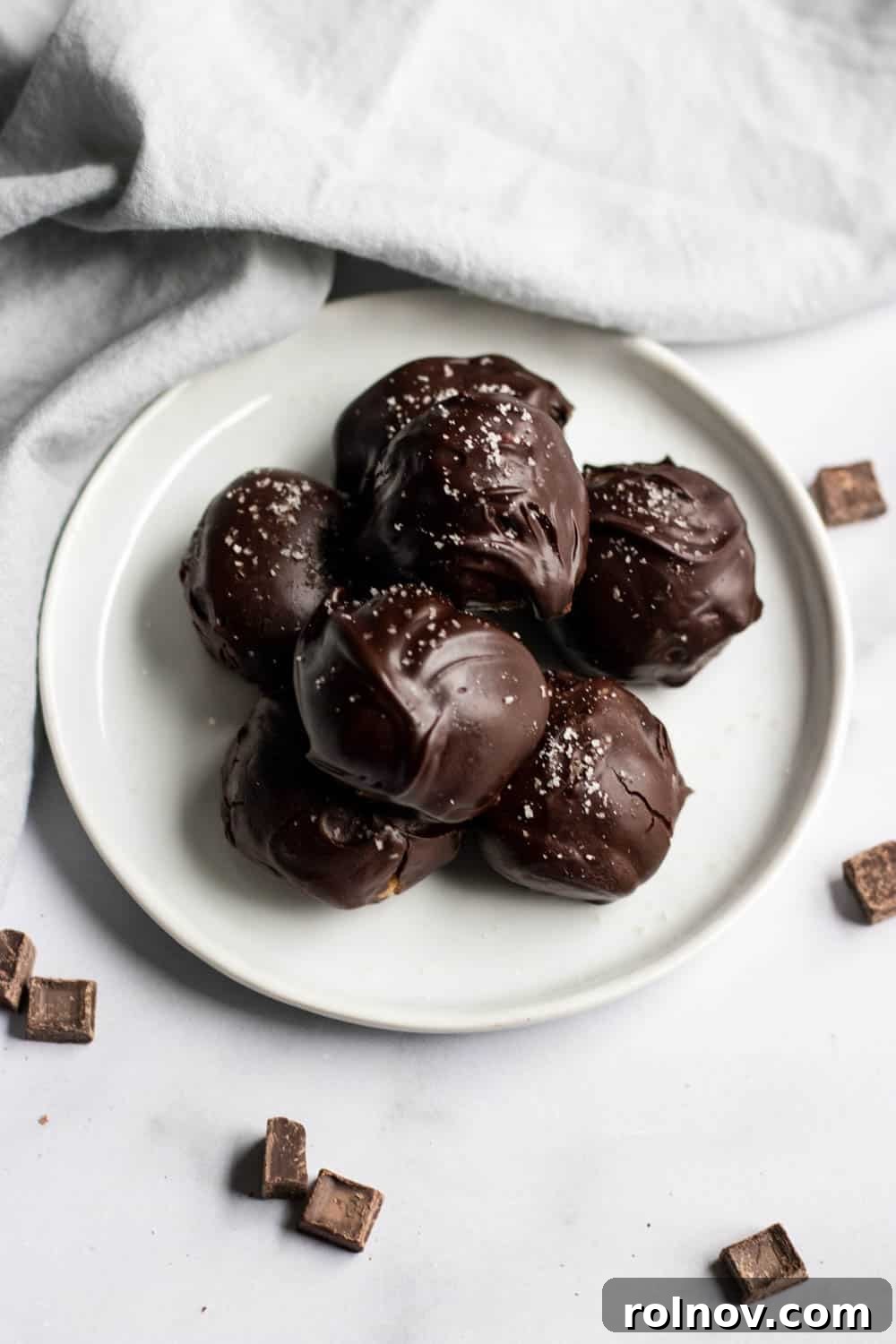 Decadent Homemade Peanut Butter Cup Truffles 3 A selection of homemade peanut butter cup truffles and buckeyes arranged on a white plate, showcasing the various shapes and the dual appeal of the recipe.