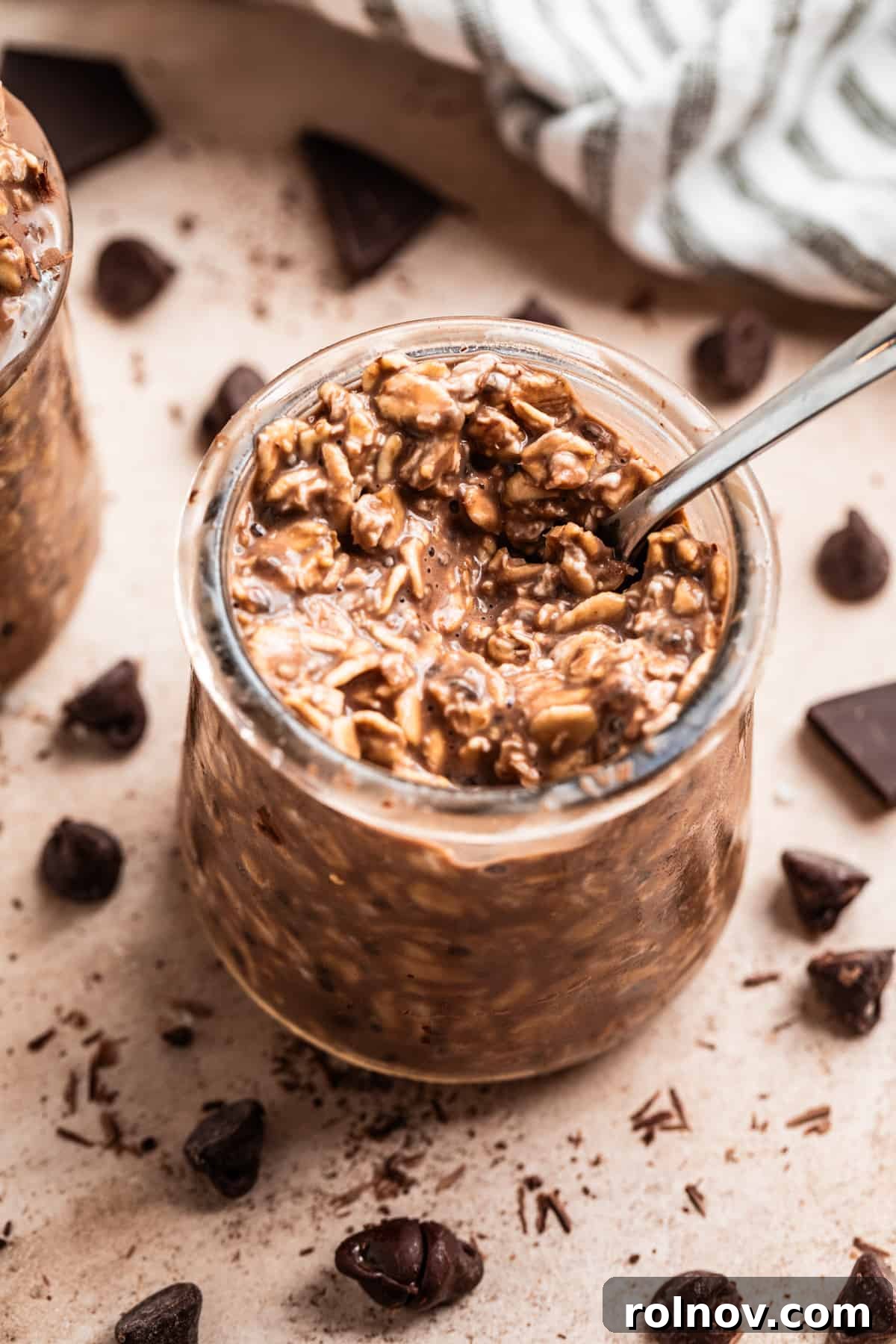 Spoon scooping into jar with chocolate overnight oats.