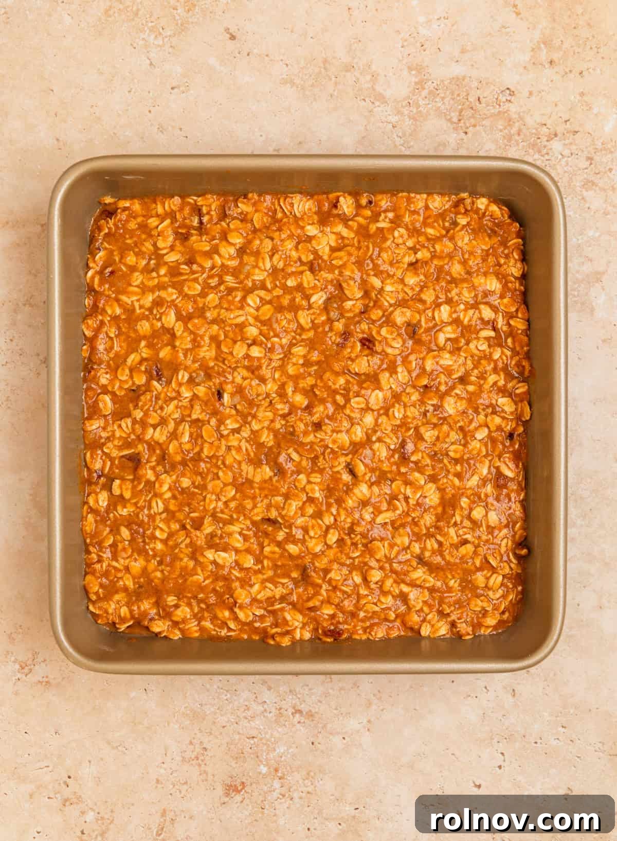 Spiced Pumpkin Oatmeal Bake 9 The pumpkin oatmeal mixture spread evenly in a greased 9x9 inch square baking pan, topped with extra pecans and ready for the oven.