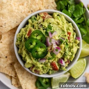 A bowl of fresh, healthy guacamole with a side of tortilla chips.