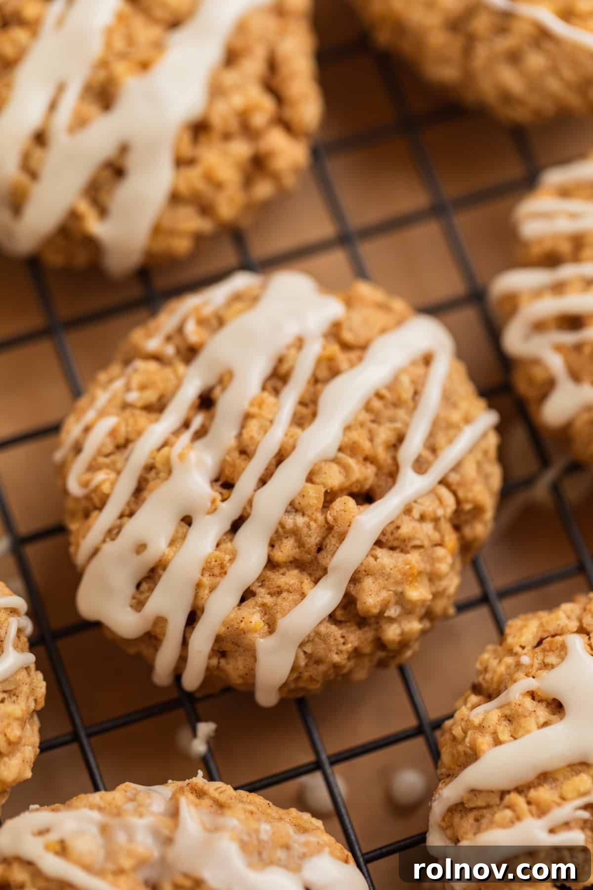Morning Cinnamon Swirl Cookies 13 A close-up view of freshly baked oatmeal cinnamon cookies, beautifully drizzled with white icing, cooling on a wire rack.