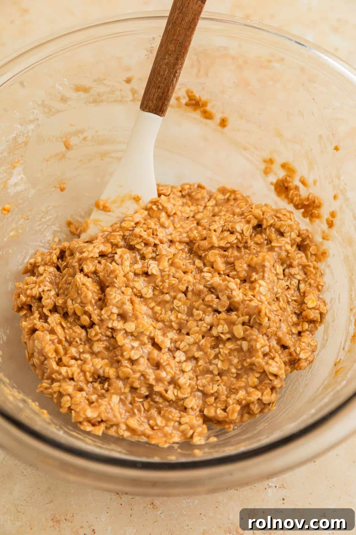 Morning Cinnamon Swirl Cookies 8 Cinnamon oatmeal cookie dough mixed in a bowl with a rubber spatula, showing its consistent texture.
