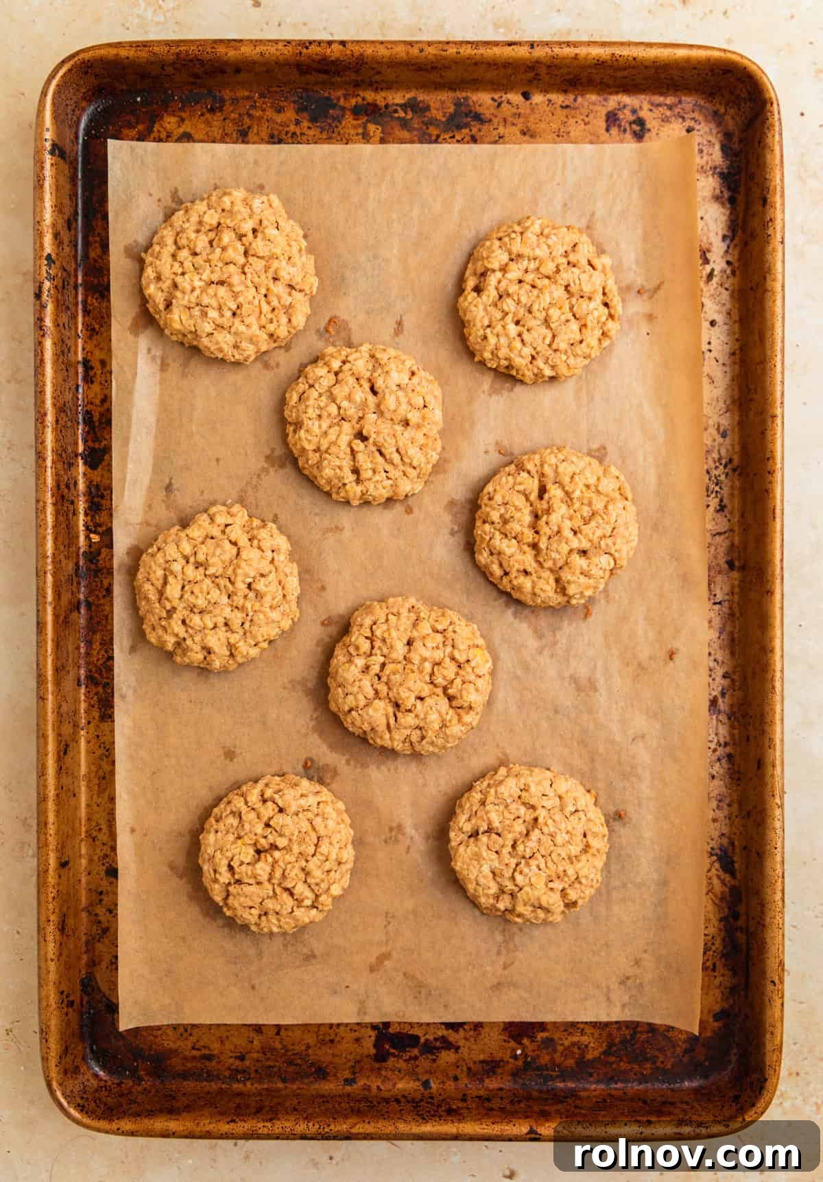 Morning Cinnamon Swirl Cookies 10 Freshly baked cinnamon roll oatmeal cookies cooling on a cookie sheet, lightly golden at the edges.