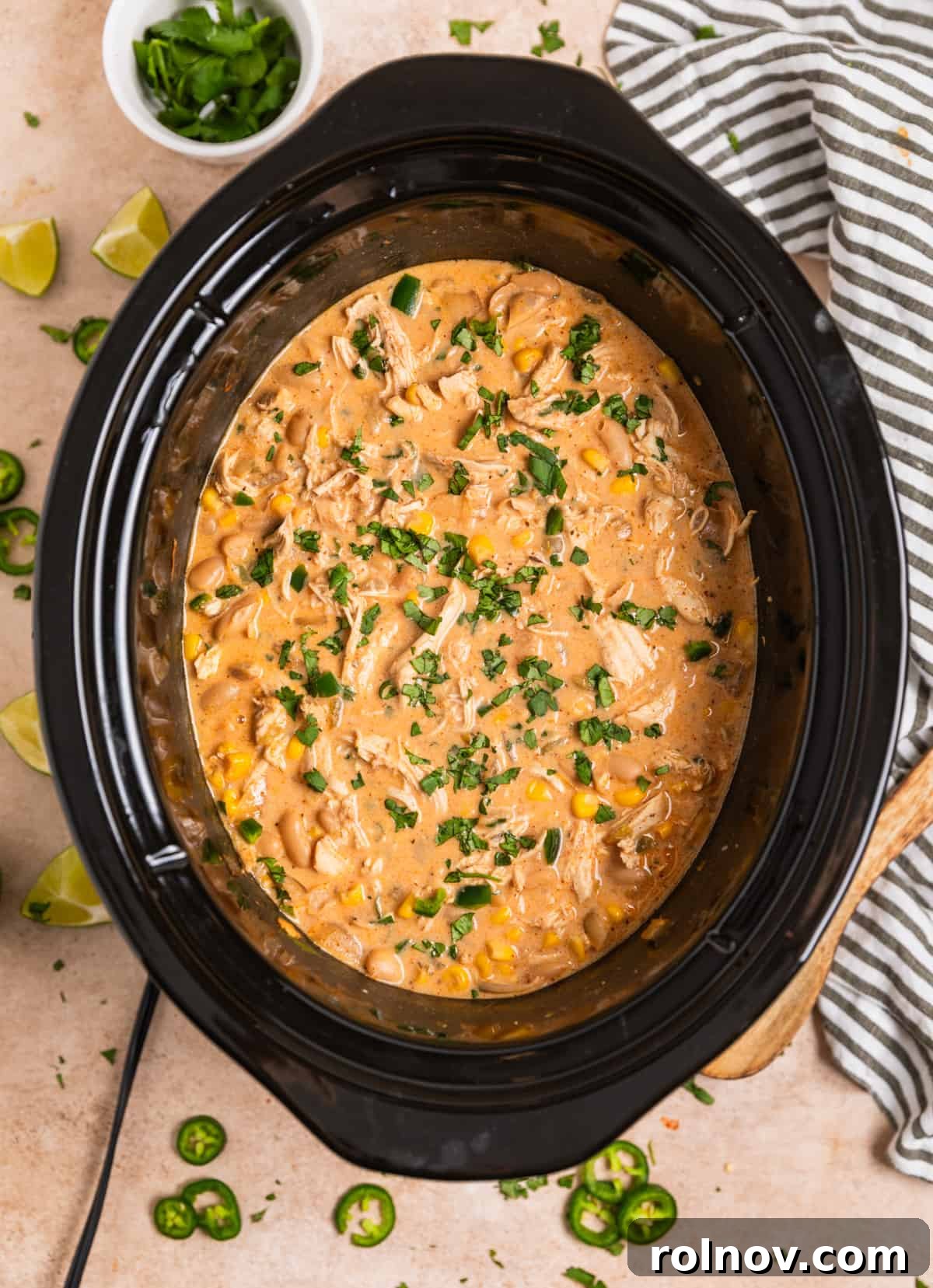 The finished slow cooker creamy white chicken chili, garnished with a generous amount of fresh cilantro, ready to be served.