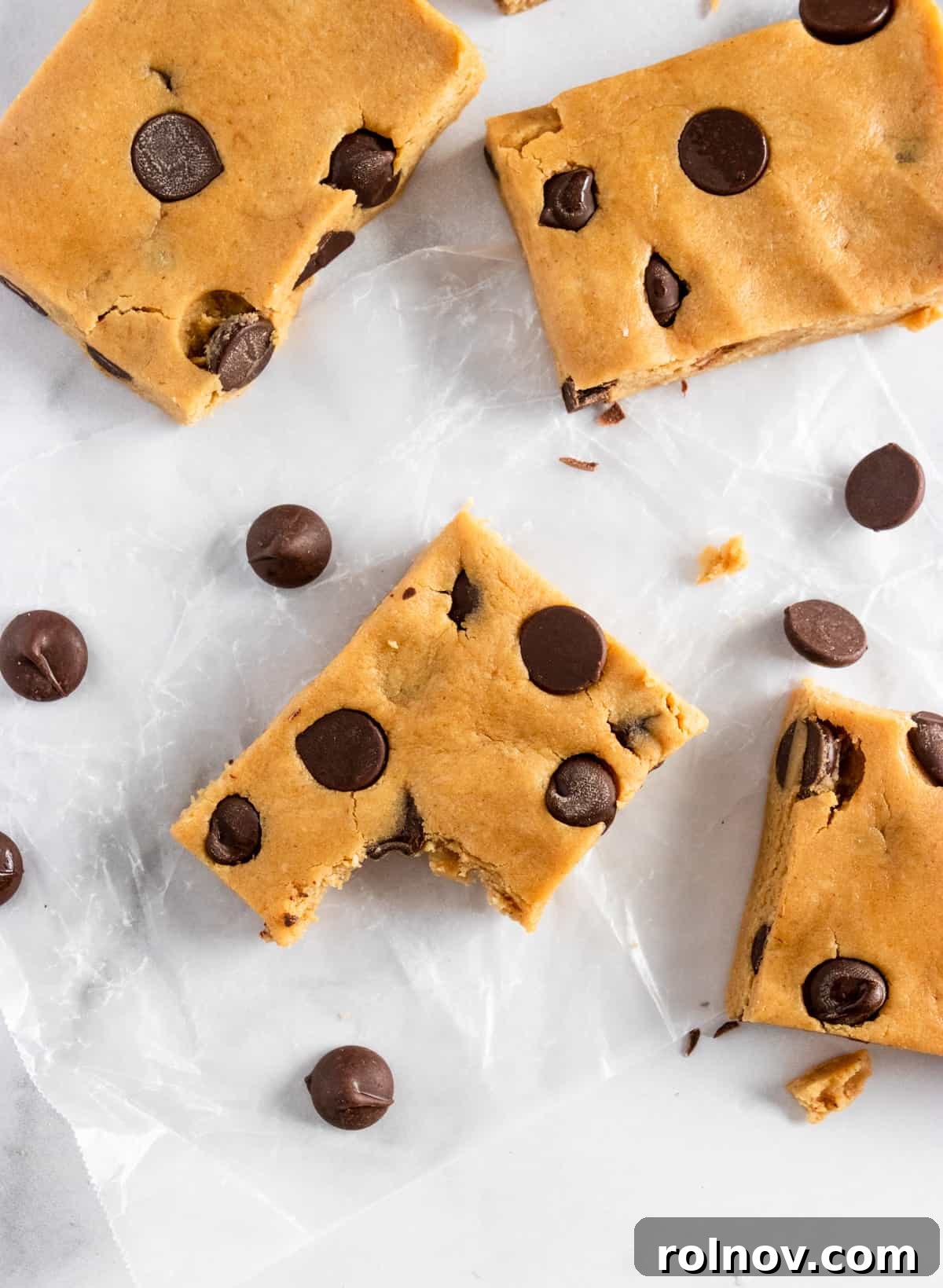 Close-up bite shot of a homemade peanut butter chocolate chip protein bar, highlighting the creamy texture and abundant chocolate chips.