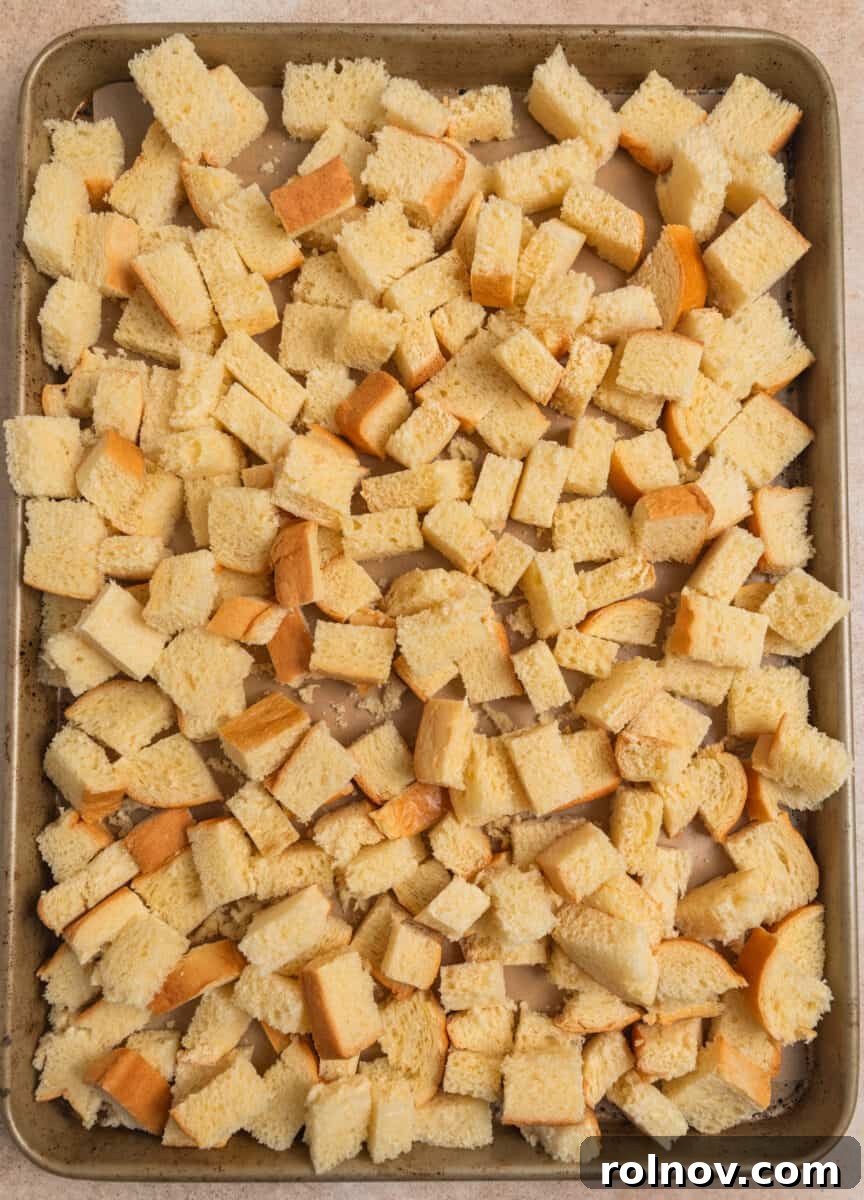 Golden French Toast Bites 4 Brioche bread cubed on baking pan.