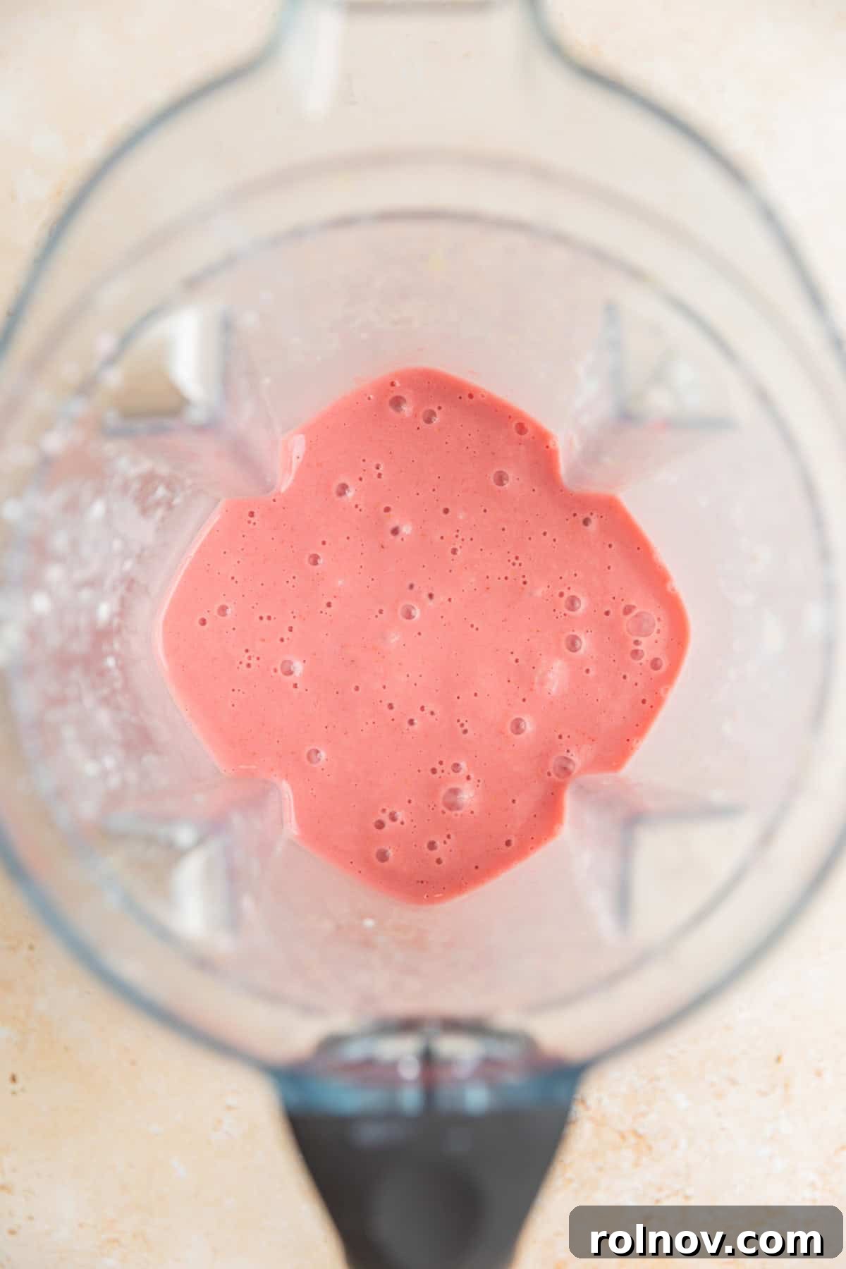 Pink Sunshine Smoothie 4 Strawberry lemon smoothie mixture blended to a smooth consistency in a blender.