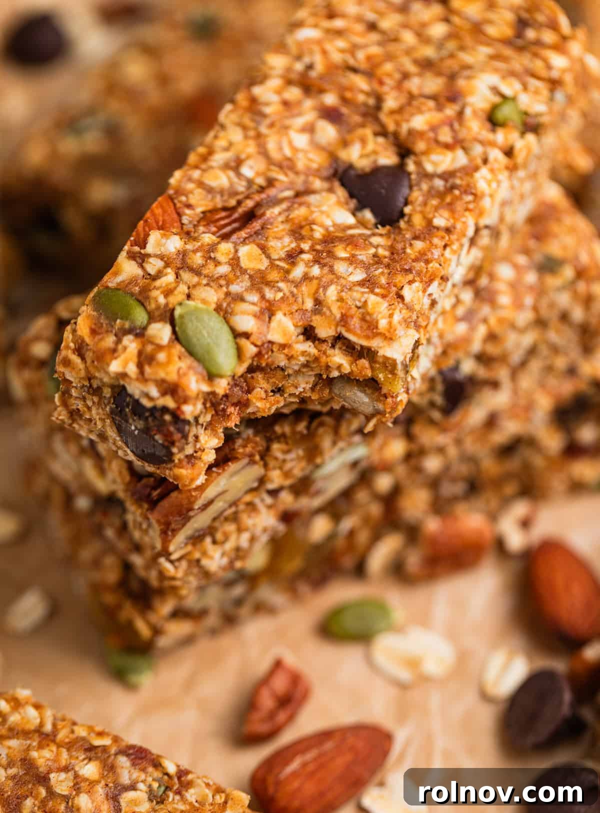 Adventure Fuel Bars 12 A stack of golden no-bake trail mix bars, with a bite taken out of the top bar to show its dense, chewy texture.