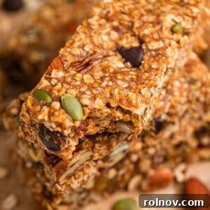 Adventure Fuel Bars 14 No bake trail mix oat bars stacked on top of each other with bite taken out of top bar.