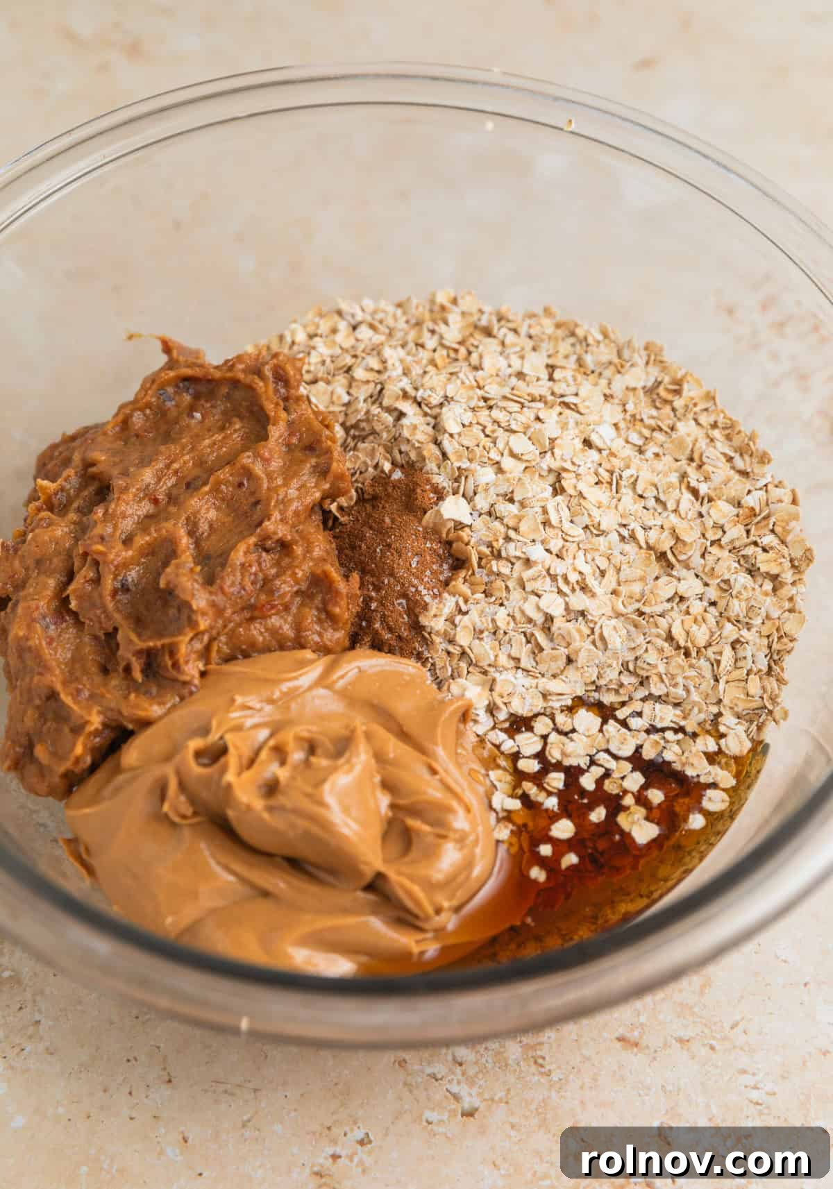 Adventure Fuel Bars 6 Quick oats, creamy peanut butter, date paste, and maple syrup in a large glass mixing bowl.
