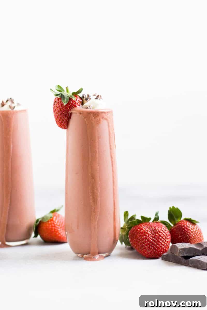 Decadent Strawberry Chocolate Swirl 2 A vibrant Chocolate Strawberry Smoothie in a glass, garnished with fresh strawberries and chocolate shavings.