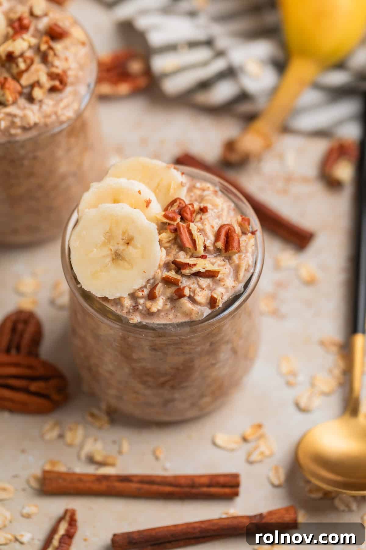 Jar of Banana Bread Overnight Oats topped with fresh banana slices and chopped pecans, ready for a healthy breakfast.