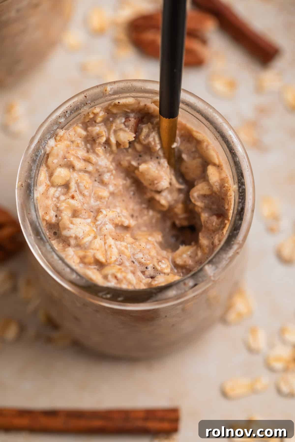 Spoon scooping into a jar of banana overnight oats, showing the creamy texture.