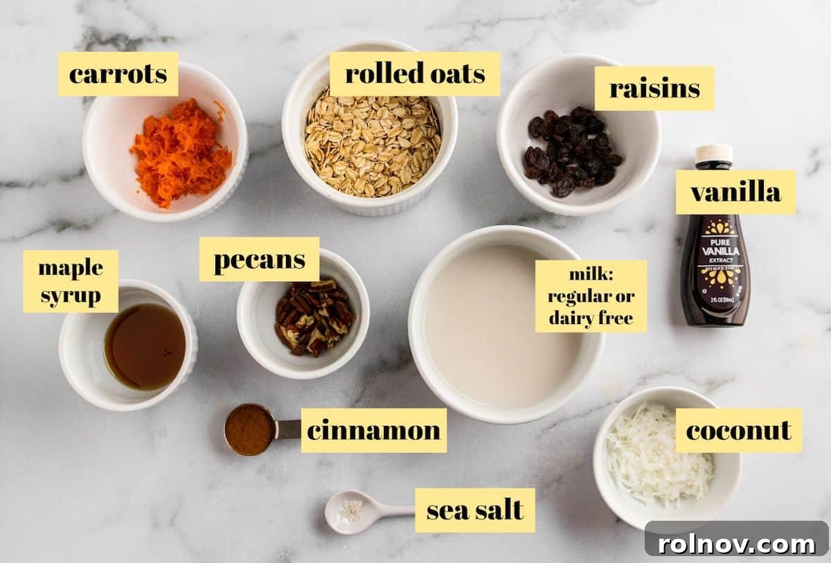Spiced Carrot Cake Overnight Oats 4 Ingredients for making carrot cake overnight oats laid out on a wooden surface: rolled oats, shredded carrots, milk, maple syrup, cinnamon, vanilla, pecans, raisins, and coconut.