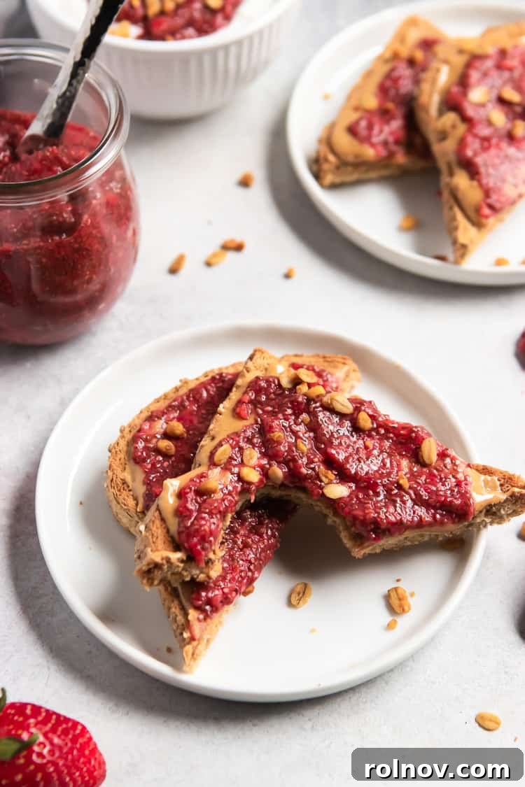 Close-up shot of homemade strawberry chia jam generously spread on a piece of peanut butter toast.