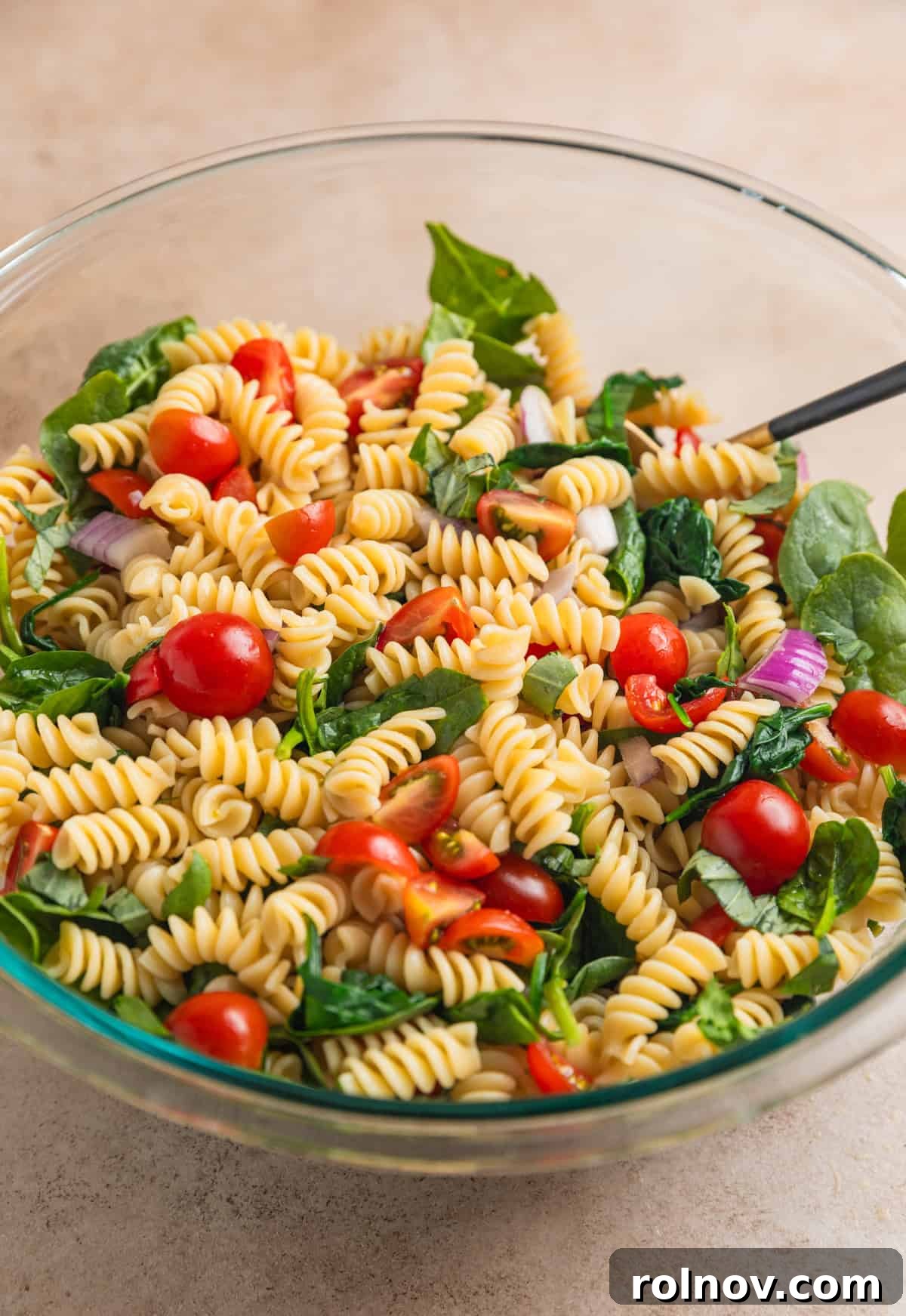Sun-Kissed Tomato Basil Pasta Salad 6 Tomato basil pasta salad ingredients tossed together in bowl.