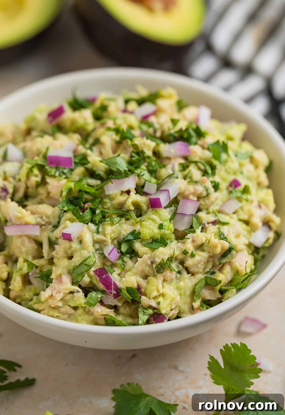 Creamy Avocado Ranch Tuna Salad 2 Avocado tuna salad in bowl topped with chopped cilantro and diced red onion.