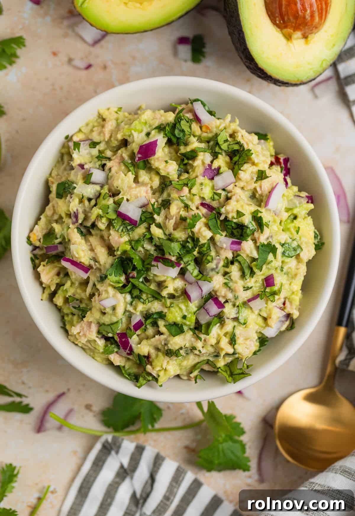 Creamy Avocado Ranch Tuna Salad 3 Avocado ranch tuna salad in dish with spoon, cilantro and linen beside it.