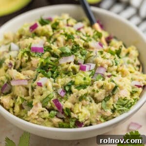 Creamy Avocado Ranch Tuna Salad 8 Bowl with spoon scooping into avocado tuna salad in bowl.